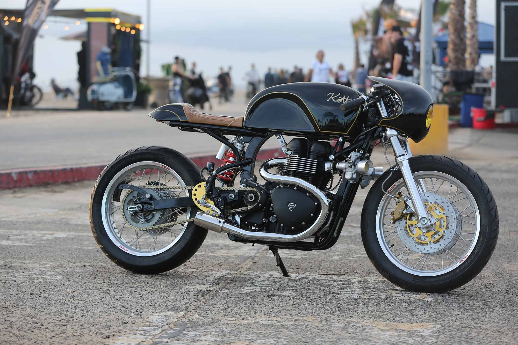What looks like a clean and classic cafe racer at first glance belies some serious machine work. With velocity stacks in the wind, this modern Triumph mashup features a reversed top end. Built by Dustin Kott of Kott Motorcycles.