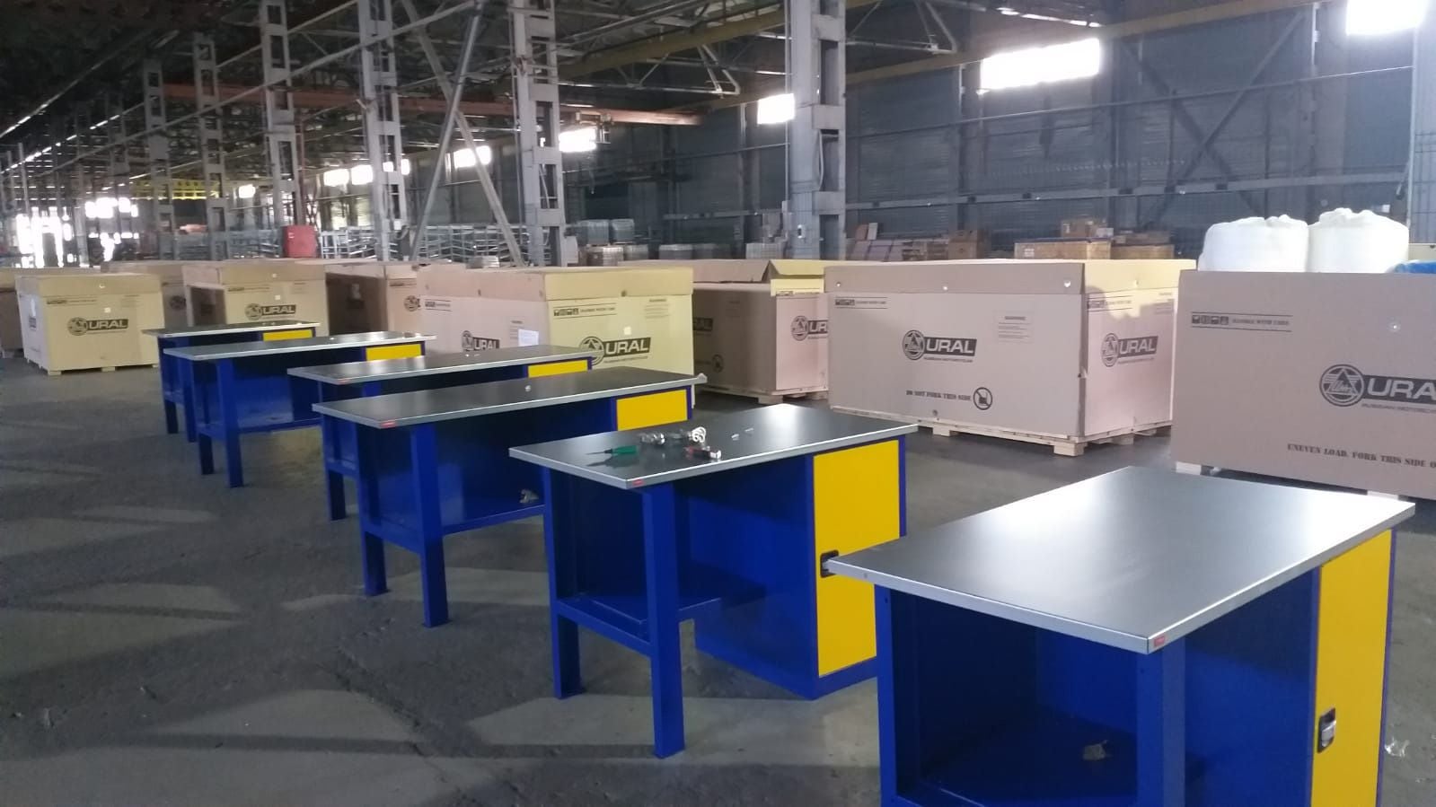 Signs of life. Racks of parts, assembly stations, and crates for fully assembled motorcycles.