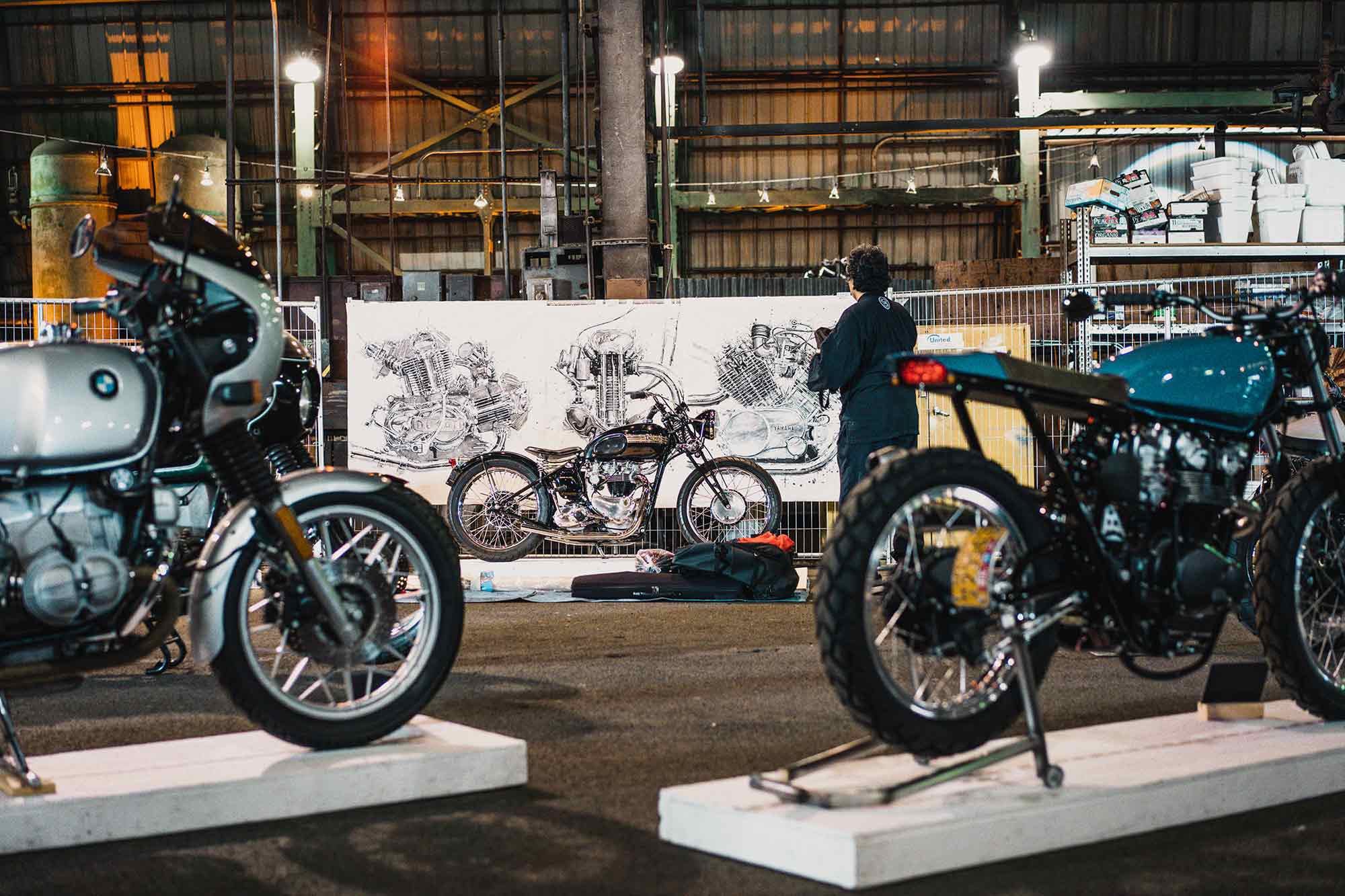 Makoto Endo paints historic engines in front of the crowd at the One Moto Show.