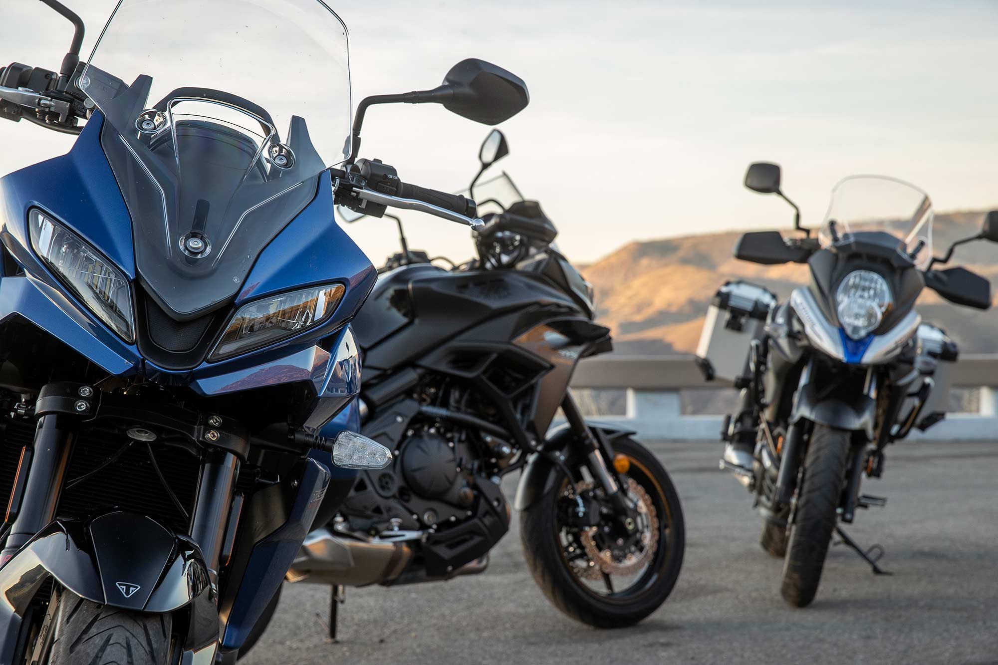 The face of the road-focused middleweight adventure bike category. The sportier front fairing of the Triumph and the beak of the V-Strom highlight different approaches.