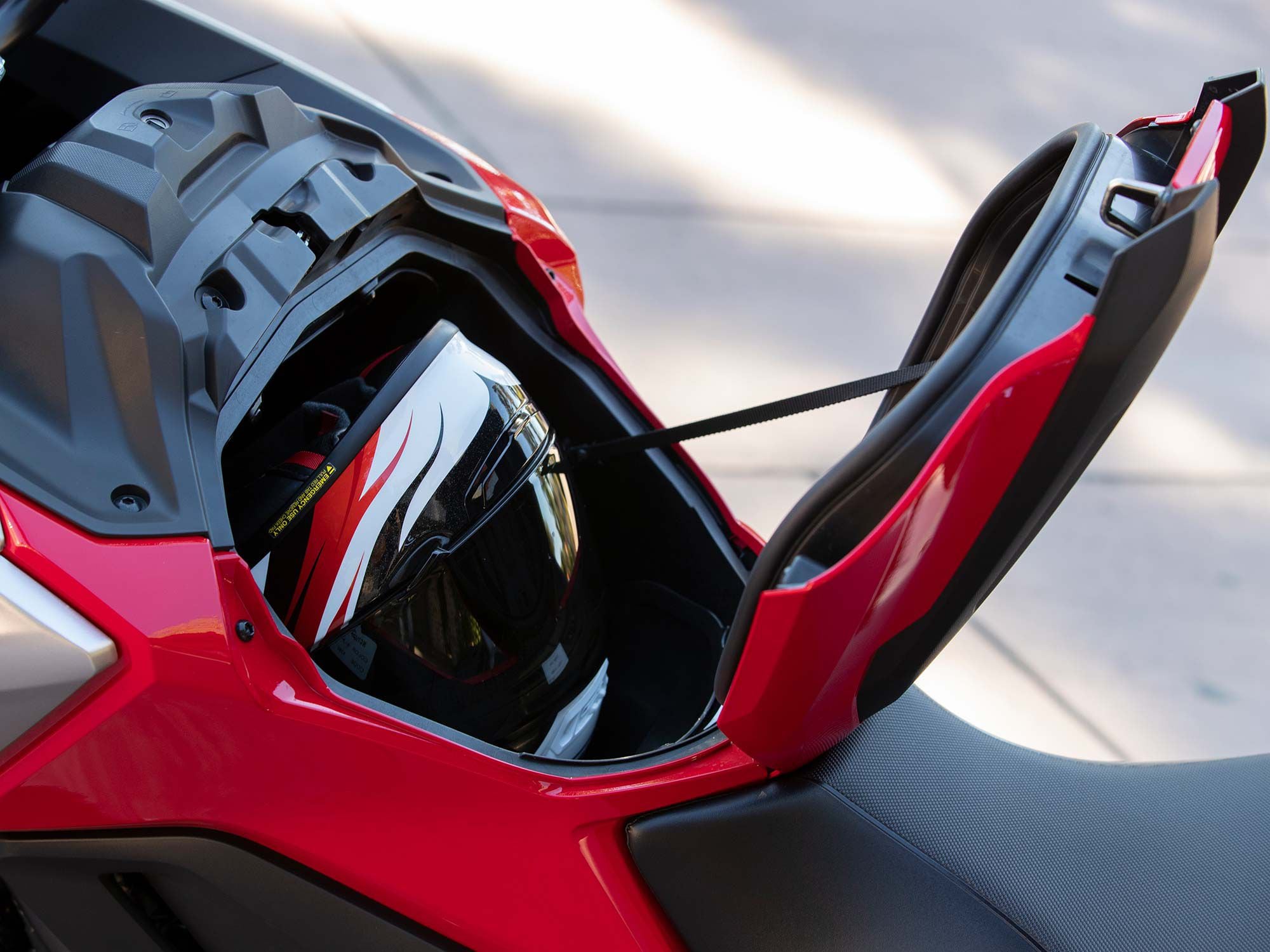 With the fuel tank located below the rider, Honda placed a handy storage compartment in front of the rider.