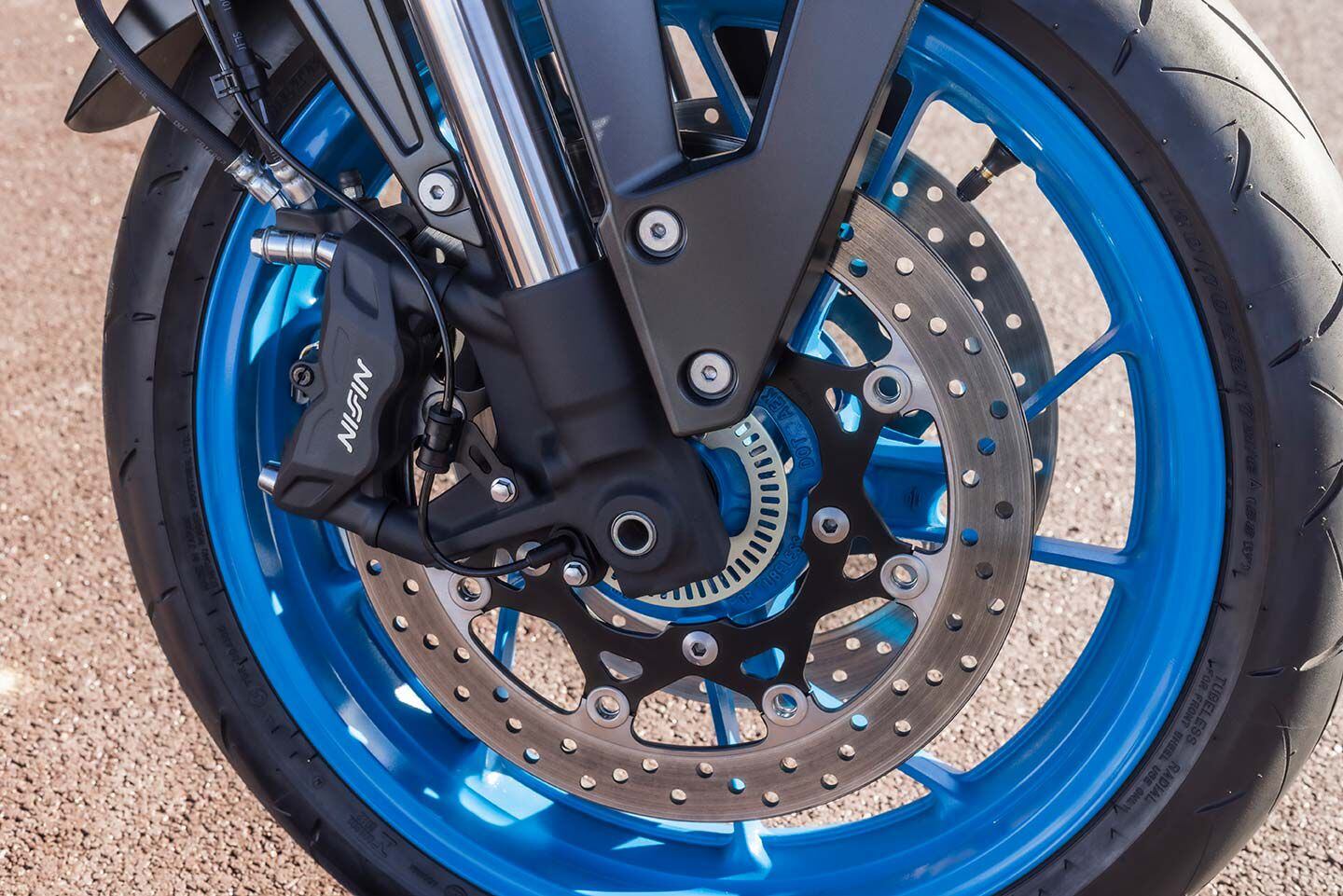 Nissin radial-mount, four-piston calipers hang on a 41mm KYB fork. Cast aluminum wheels wear Dunlop RoadSport 2 tires.