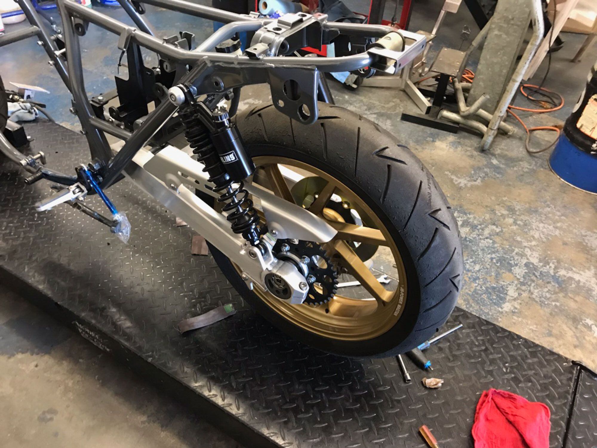 The frame went from black to gray powdercoat, with a clear over the top, to match the beauty of the JB Racing swingarm and Öhlins shocks. The black Öhlins were made for Harley-Davidson applications but Andrew has them built to specs suitable to the mid-400-pound KZ. Burac fabbed the lay-down shock mounts. The 18-inch JB Racing wheels off Andrew’s AHRMA-winning KZ were bolted on.