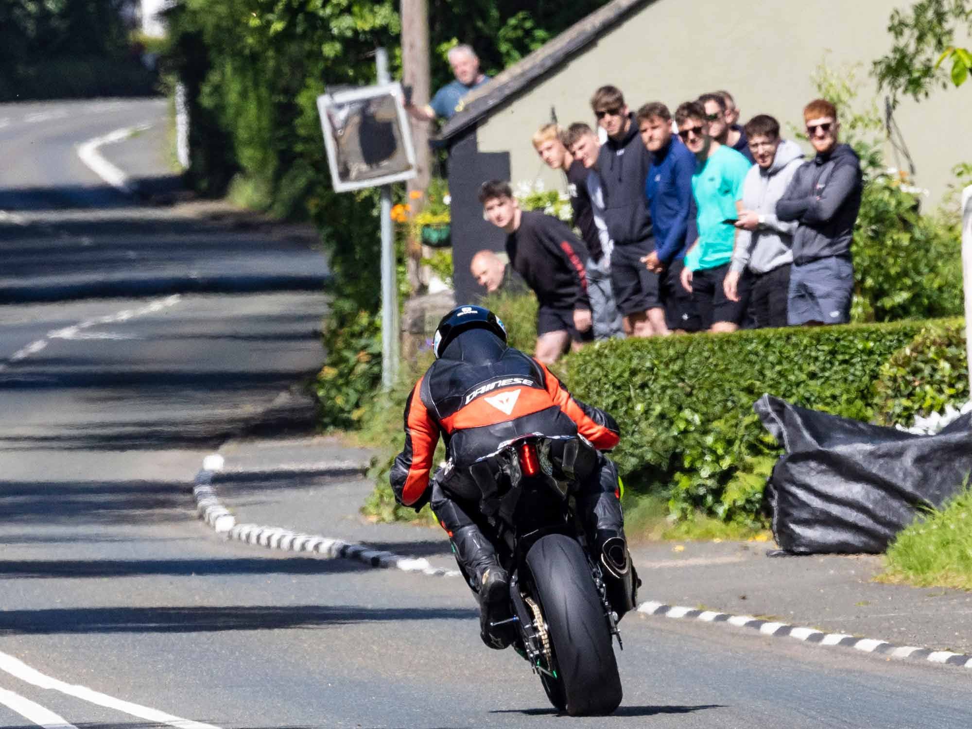 TT fans crane their necks to make eye contact with riders coming straight at them. The racing is so close that spectators feel the sound of the engine deep in their lungs as each racer skirts the hedge, trying to pick the optimum line through each turn.