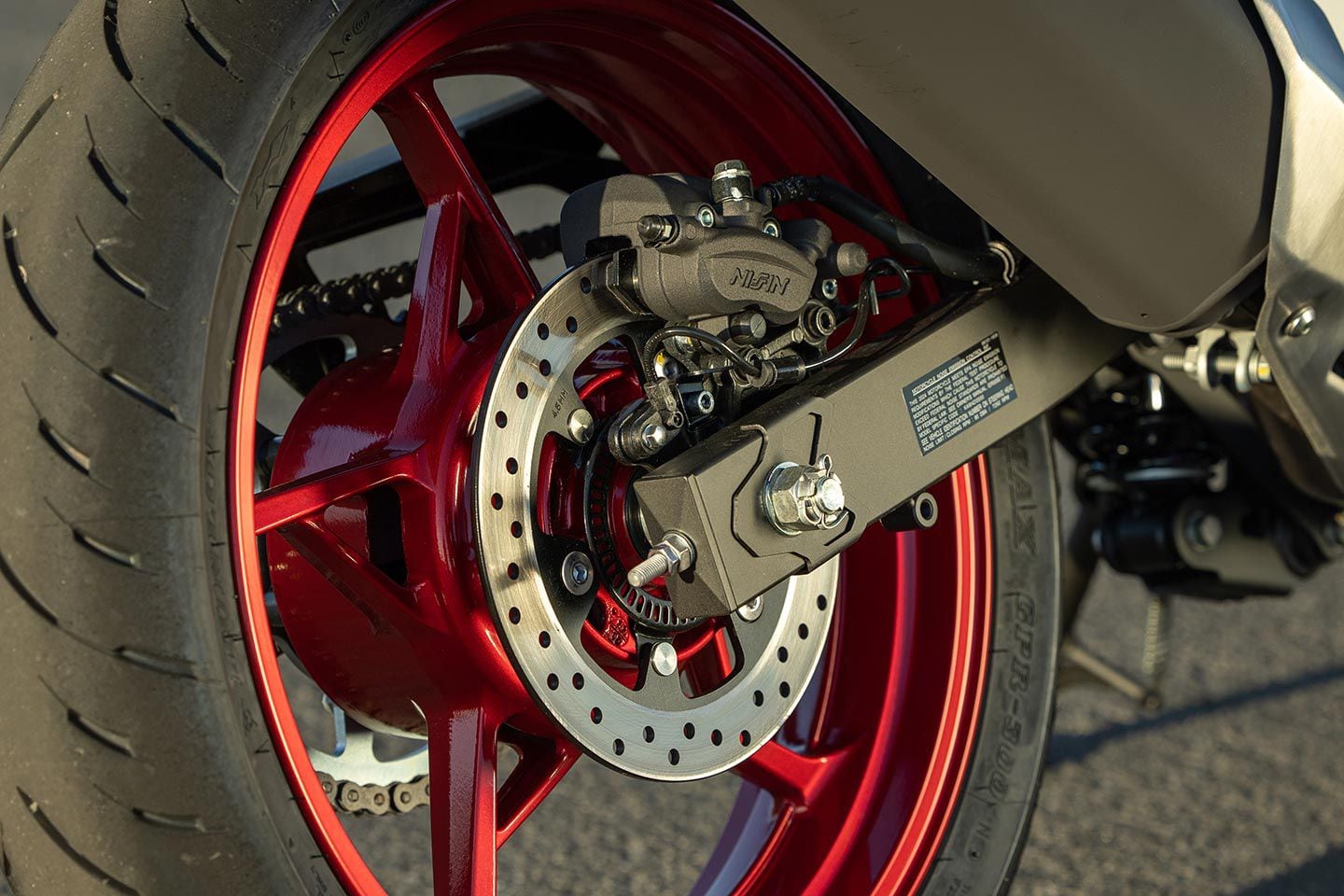 The rear brake system features a 220mm disc with a dual-piston Nissin caliper.
