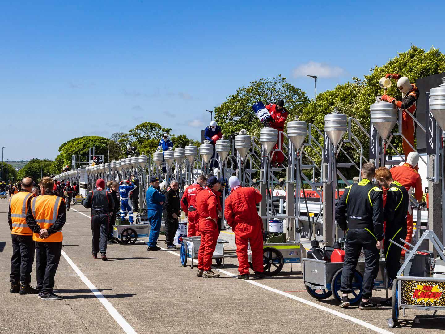 Before the race, fuel canisters are filled along pit lane. The six-lap event necessitates two fuel stops; fuel is gravity-fed from an elevated canister.