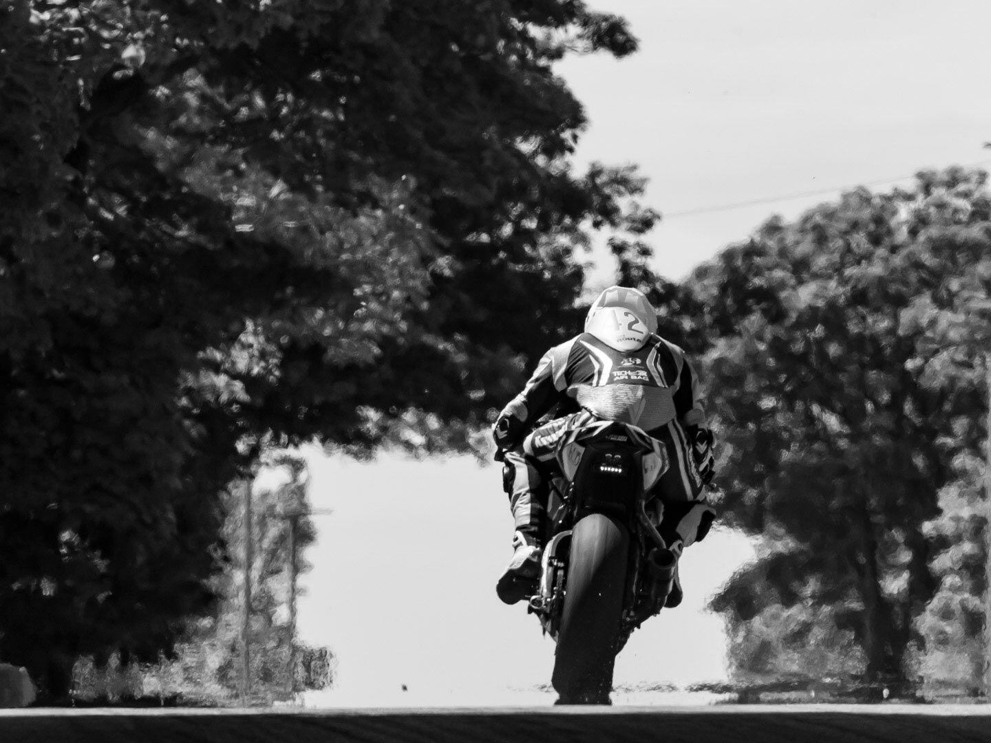 Jonathan Perry has made the final turn on his Kawasaki ZX-10 and will soon see the grandstand as he crests the horizon.