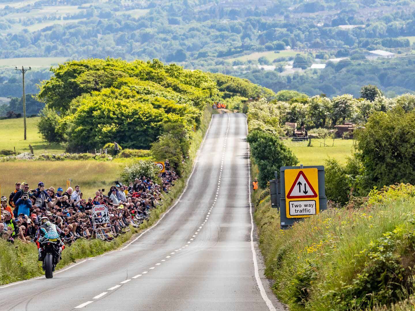 With 3 miles to go on the final lap of the first Superstock race, Hickman wheelies past the cheering crowd and his pit board reading, “P1, +22 seconds.”