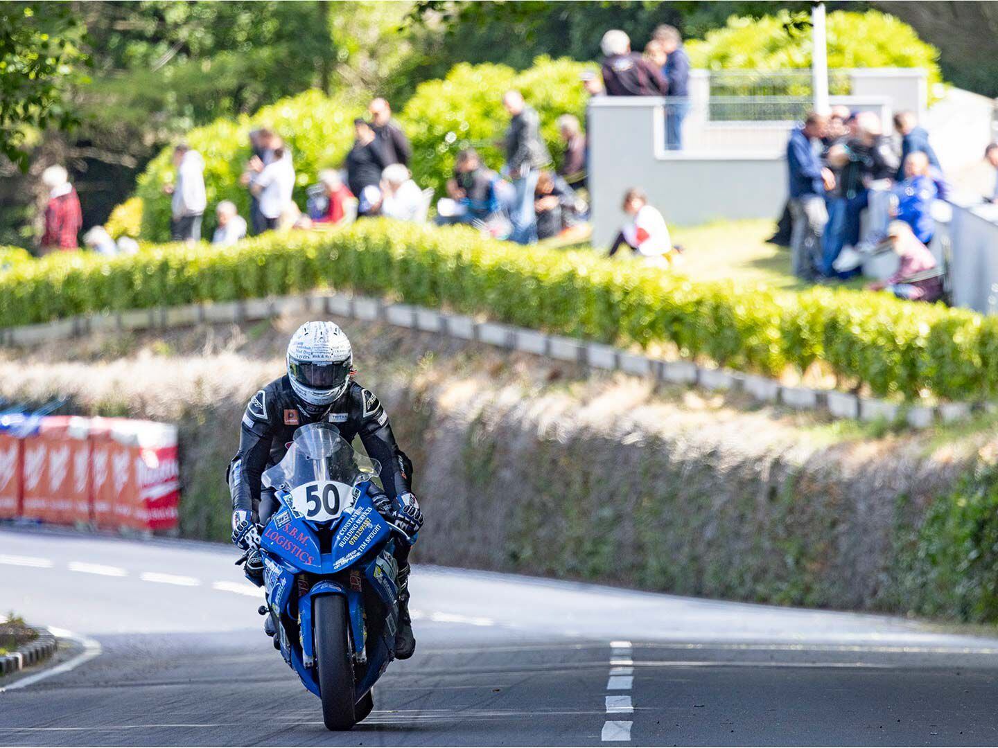 Entering the Ramsey Hairpin at 120 mph and slamming on the brakes as they approach the turn, riders stand the bike up and cut their speed to about 40 mph before setting up to lean in, as picnicking fans watch from above.