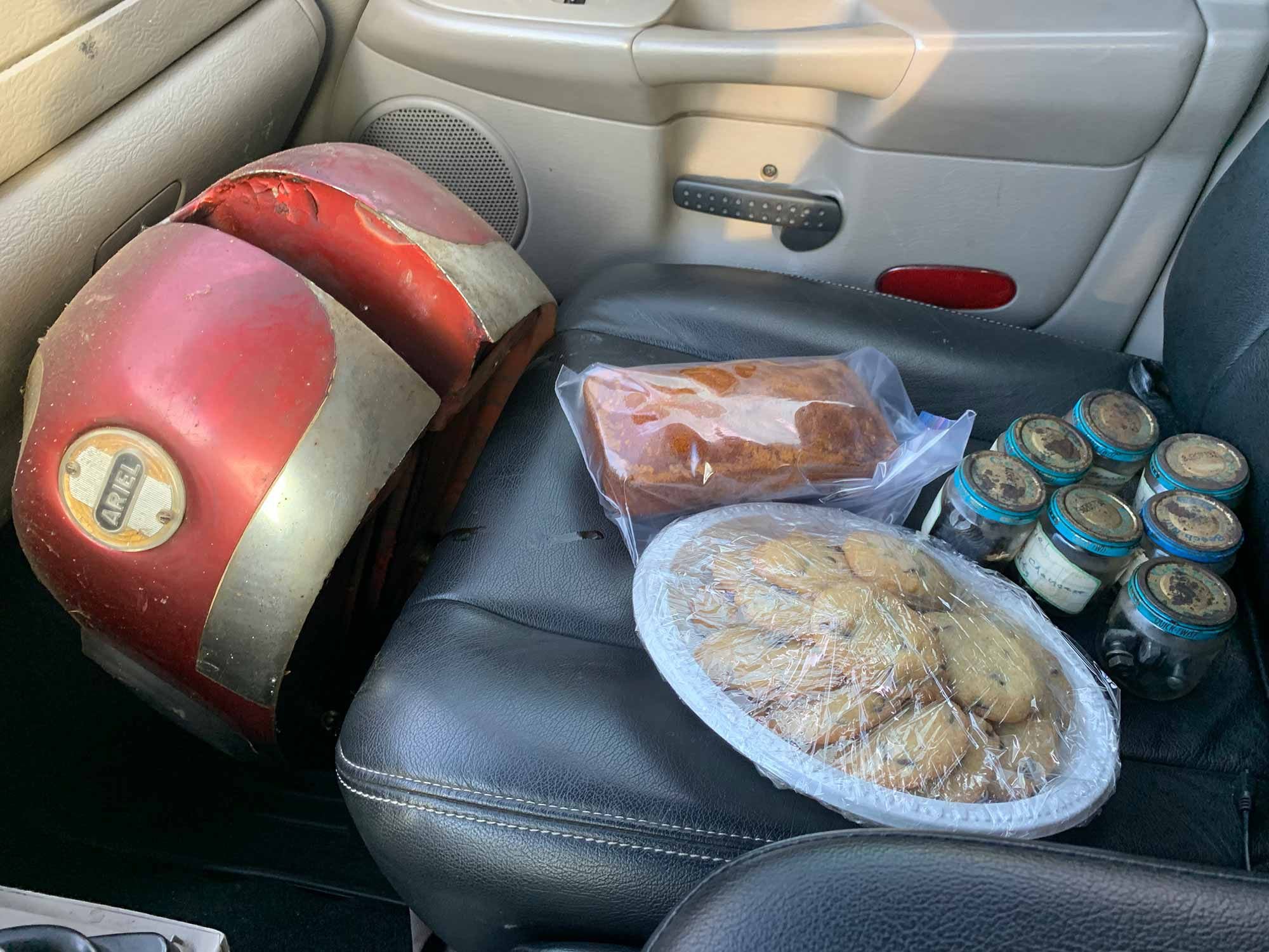 Leaving Ruthie’s house, J’s passenger seat holds an Ariel Square Four gas tank, some old jars of nuts and bolts, and some homemade pumpkin bread and cookies.