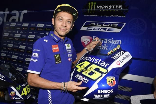Download Valentino Rossi in action during a Yamaha team race. Wallpaper