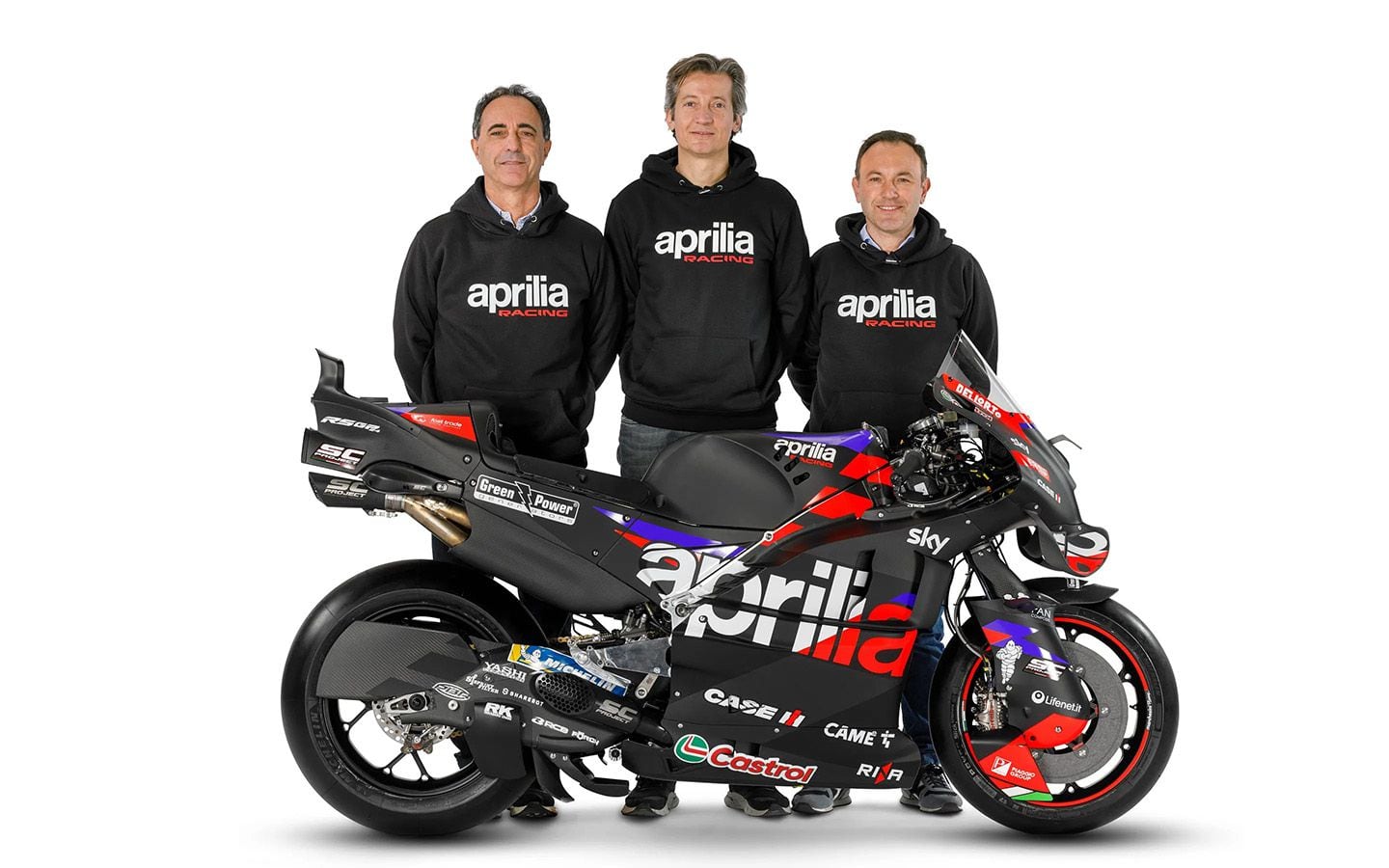 Left to right: Romano Albesiano, Massimo Rivola, and Paolo Bonora with the Aprilia RS-GP24.