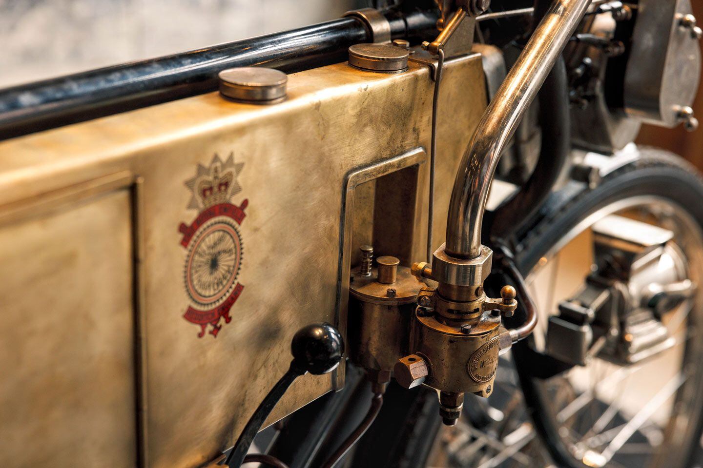 A detail of the carburetor attached to the fuel portion of the brass tank. Note the bleed pipe (right side) coming from exhaust, to help warm the fuel-air mixture.