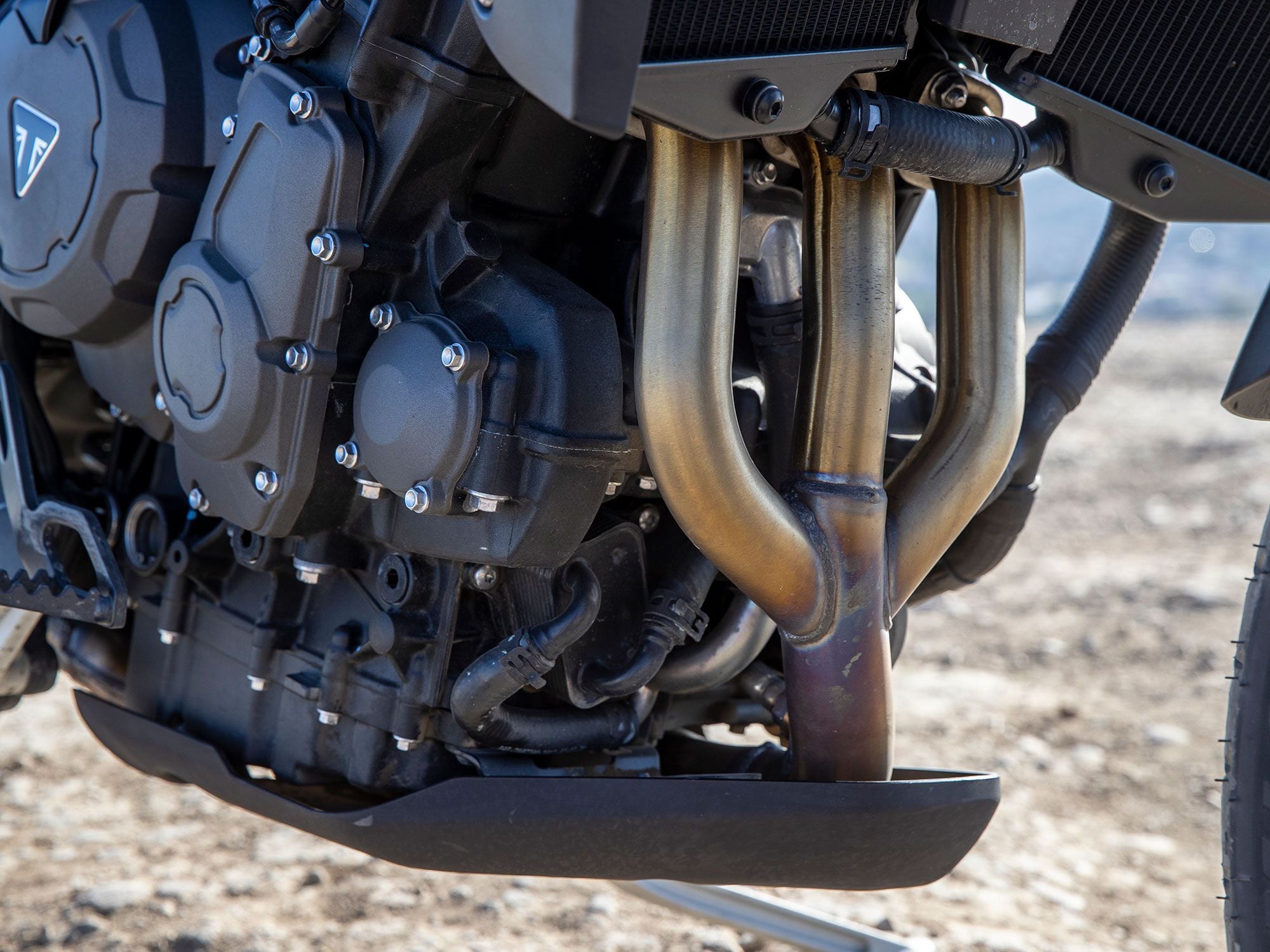 The trademark trident-shaped exhaust headers of a Triumph triple.