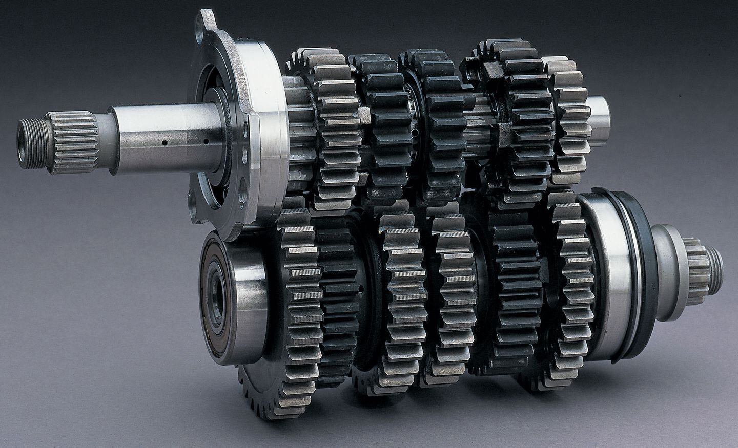 Modern motorcycle transmissions have the power entering through one shaft and exiting the other.