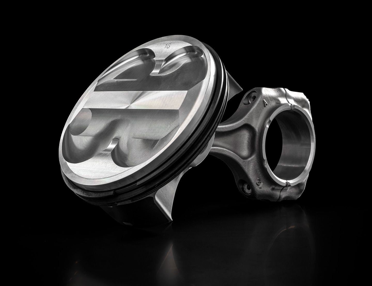 The 116mm piston atop its fracture-split connecting rod. The rod is slightly shorter than that used in the 1299 Panigale, despite the Superquadro Mono’s slightly longer stroke—62.4mm versus 60.8mm. The hidden bottom of the piston is “box-in-box” reinforced—think of a multiroom apartment below the piston crown whose walls give great strength and pick up the short wrist pin. An oil jet is aimed at piston bottom for cooling.