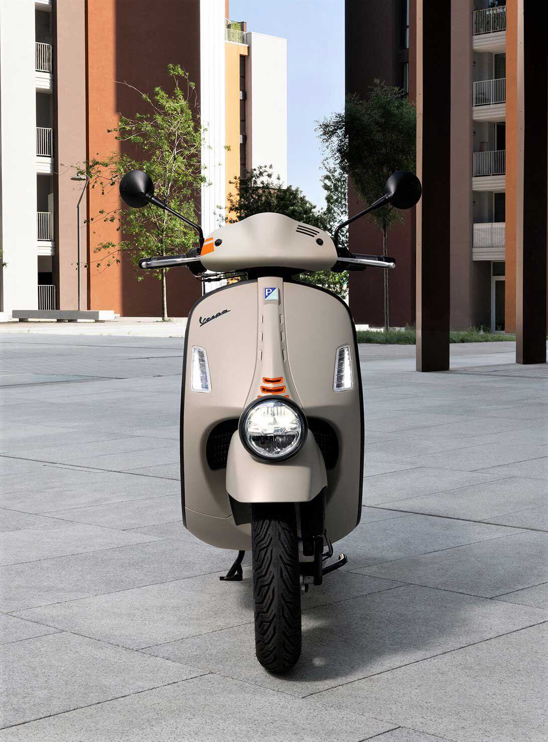 The signature Vespa “neck-tie” with its triple air vents on either side and orange central grilles on the front of the fairing.