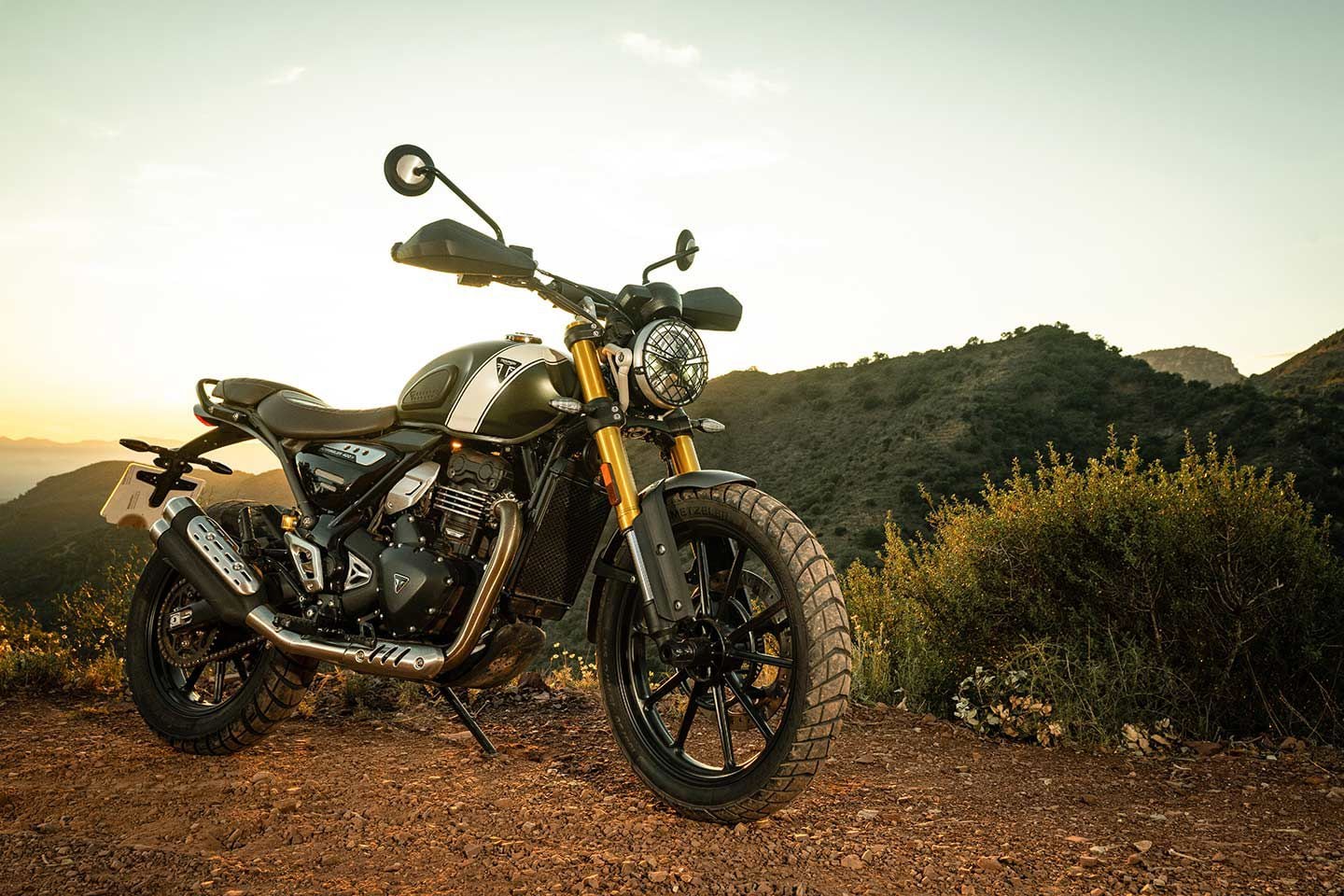 Triumph’s Scrambler 400 X gets a host of parts to set it apart visually from the Speed 400: a headlight grille, skid plate, dual-tip muffler, and hand guards. It also has a taller, wider handlebar.