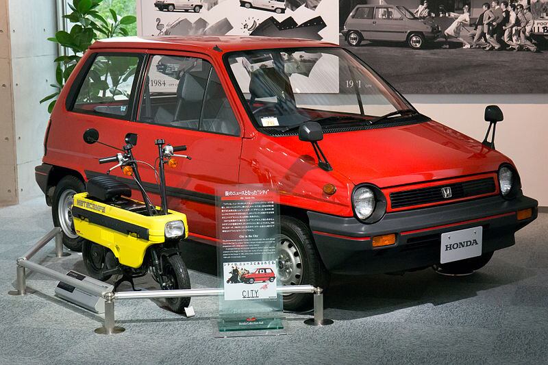 The original Motocompo of the ’80s was designed as the ultimate commuter combination. Use the car to get to the outskirts of town and then pull the two-wheeler out for the final run into the city.