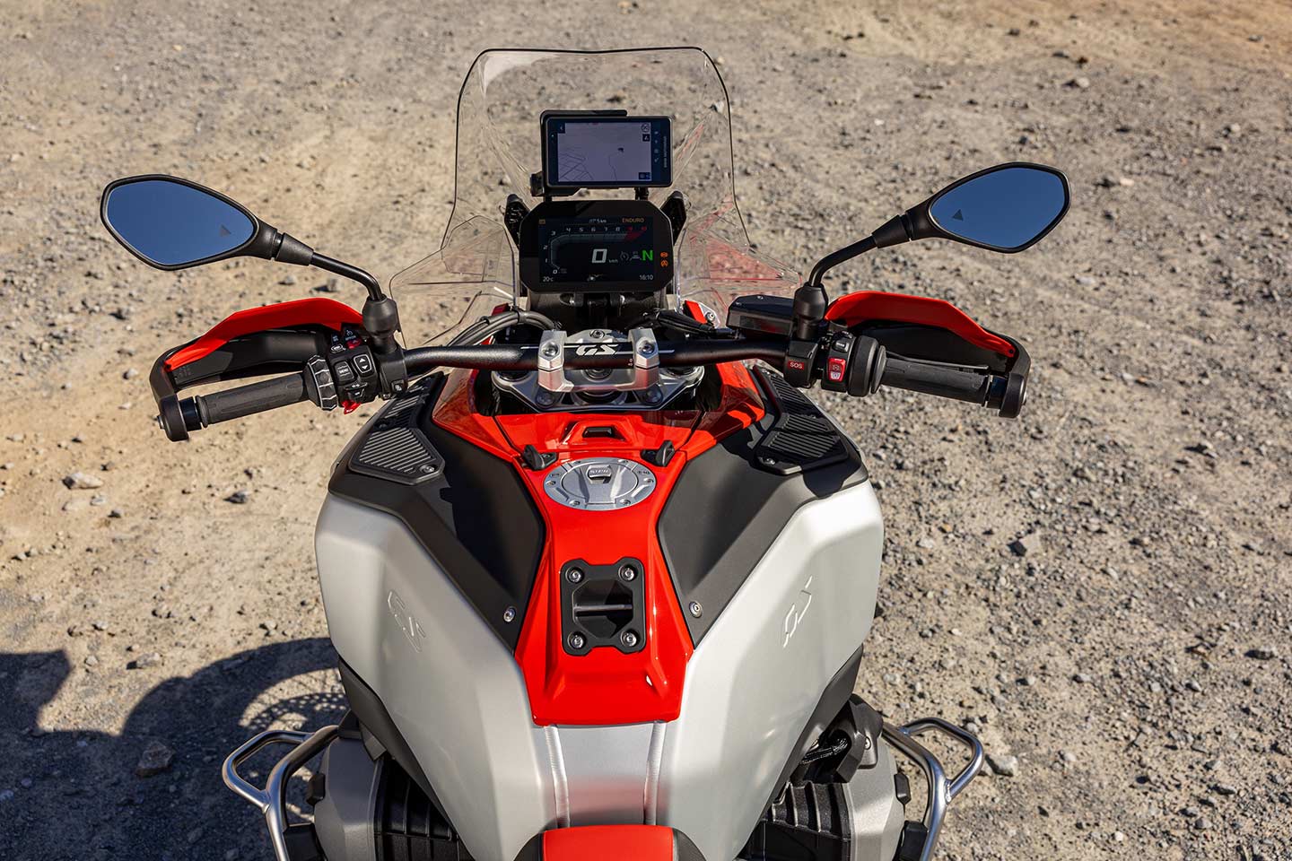 Cockpit view shows generous front width of the tank and mounting points as well as 6.5-inch full-color TFT and secondary Sport screen which displays additional info. The electronics package includes four riding modes, Dynamic Suspension adjustment, Dynamic Cruise control, traction control, and more. Windshield is height adjustable.
