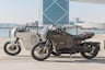 Honda E-VO electric motorcycles parked on sidewalk