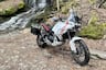 Ducati DesertX outfitted with accessories parked next to waterfall