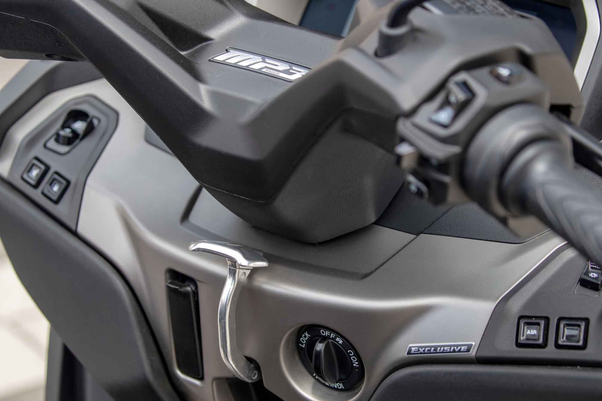 The silver lever in the center is part of the MP3′s parking brake system, a necessity due to the no-shift CVT transmission.