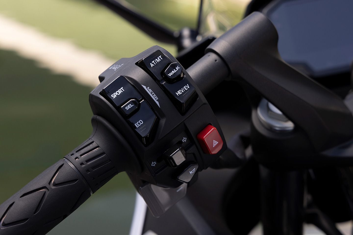 Switch cluster on the left-side handlebar has all of the buttons for switching between ride modes, automatic or manual transmission, and hybrid or electric power. Buttons also enable you to activate Walk mode and navigate vehicle settings through the TFT display