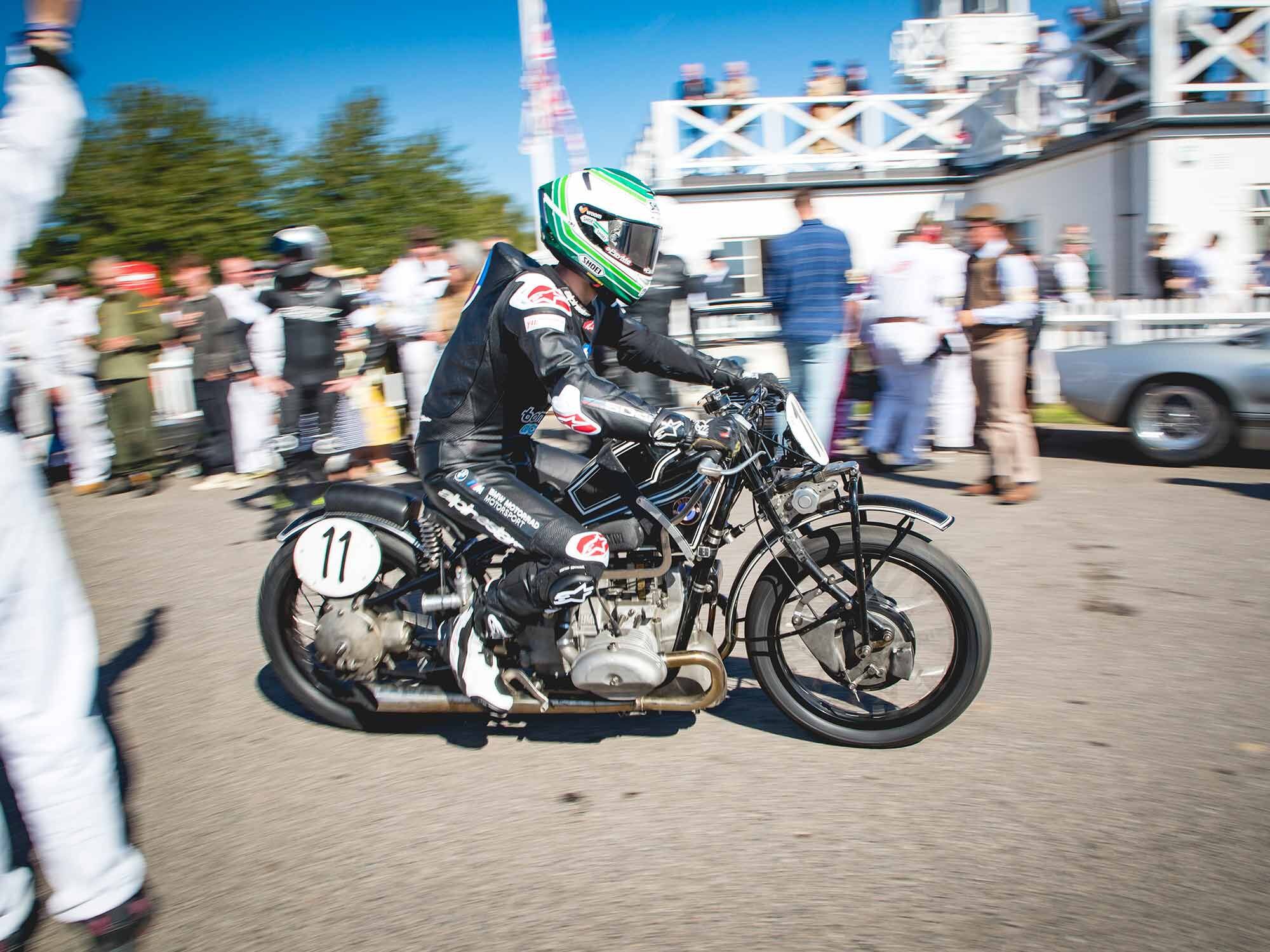 BMW world superbike racer Eugene Laverty leaves the paddock on his Goodwood Revival racebike, a 1929 R 57 supercharged 500cc flat twin that rips out about 75 hp in its rigid frame.